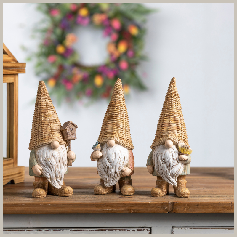A set of three gnomes. Each wearing a faux wicker hat. Wood grain design bodies. Long white beards. Each one holds either a butterfly, birdhouse or bluebird. Delightful.