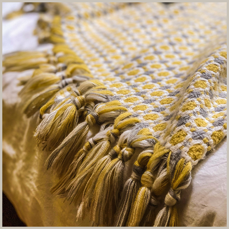 Gold &amp; Gray Knitted Throw with a close- up view of the tassels and texture. 
